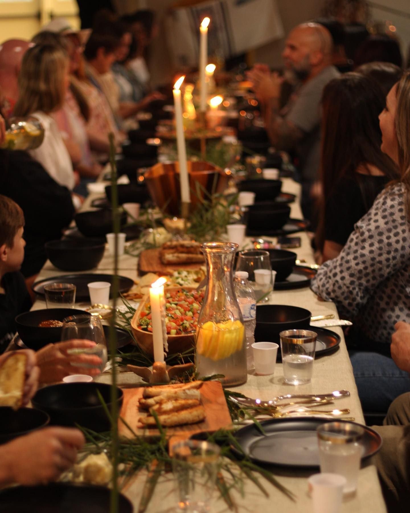 Community gathered around a candlelit table